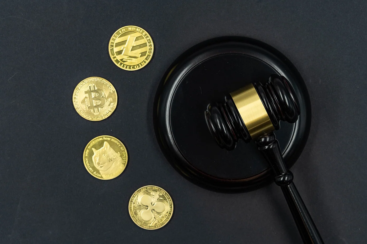 Cryptocurrency medallions beside a gavel, photographed for legal and regulatory context