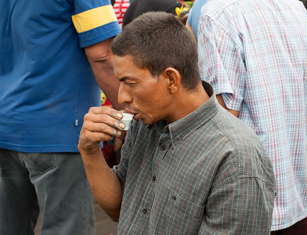 A coffee-drinking vegetable seller at a flea market in Maracaibo, Venezuela.