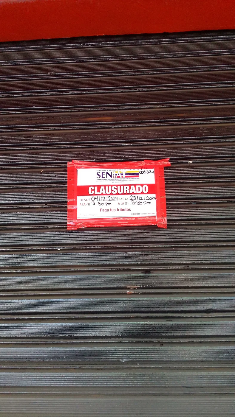 SENIAT closure notice on a Venezuelan storefront