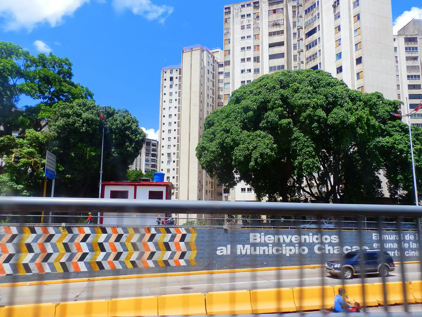 Chacao mural and high-rise buildings beside a Caracas road.