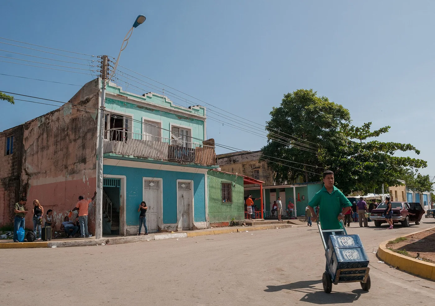 Street scene near the Bolivarian University of Venezuela on Margarita Island, with people outside colorful houses.