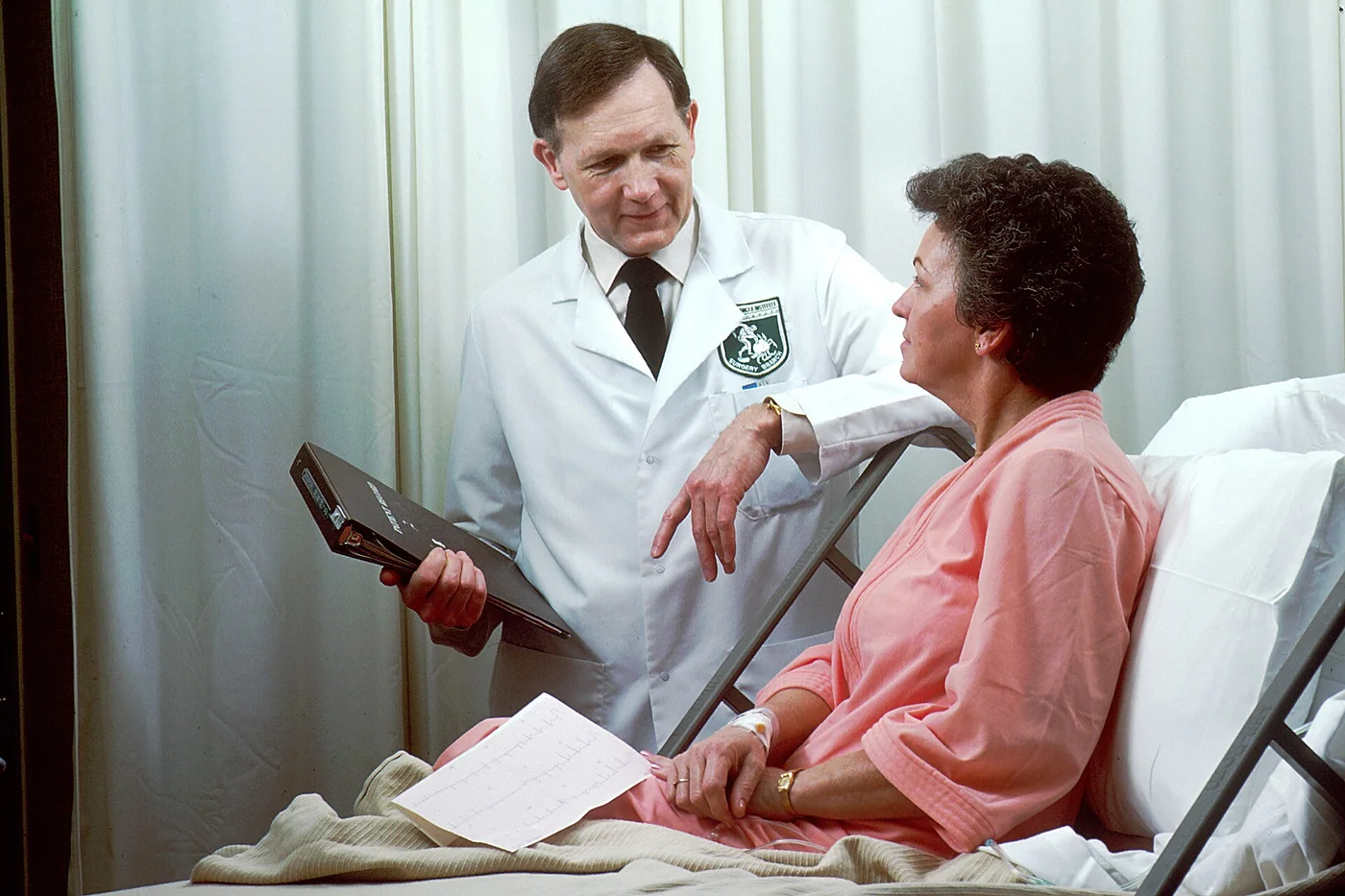 National Cancer Institute oncology doctor consulting a patient in a hospital bed