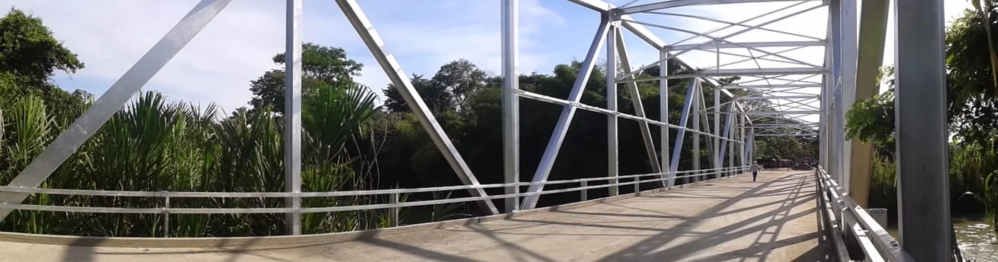 A real Venezuelan bridge is shown as logistics context, not as proof that a project has zone benefits.